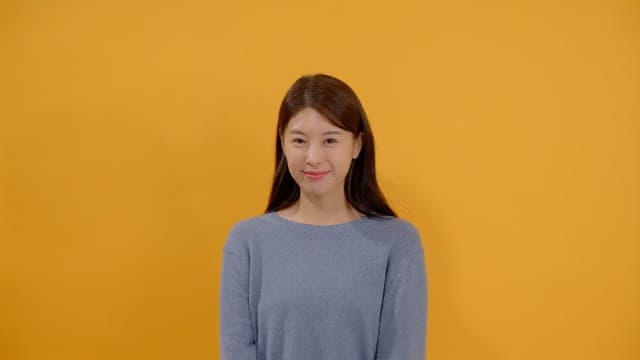 Long haired woman smiling and happy in gray sweater