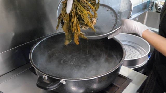 Person who parboil dried radish greens in boiling water
