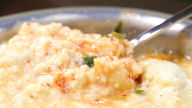 Spoonful of savory soft tofu stew with seasoning