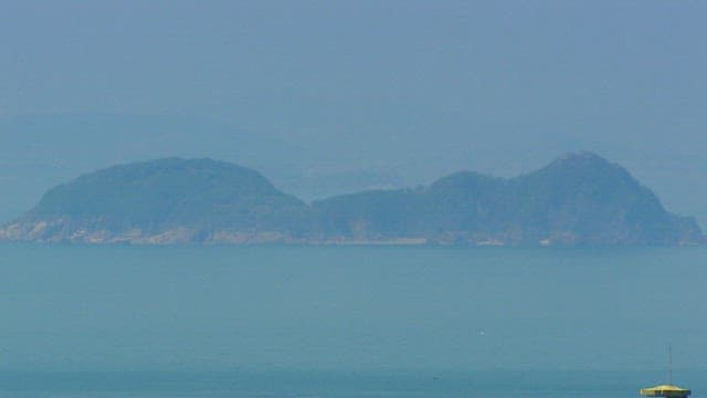 Island Vaguely Visible Across the Blue Sea