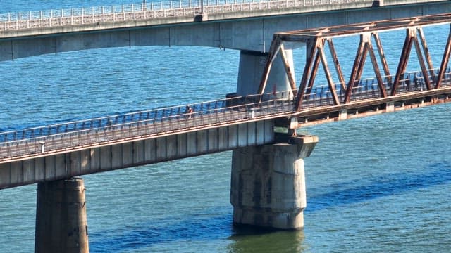 Cyclist and pedestrian on a bridge