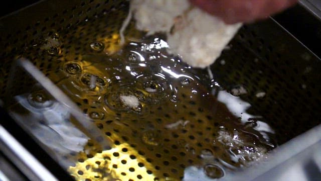 Frying breaded pork cutlet in hot oil