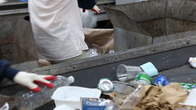 Workers sorting plastic waste on a conveyor belt