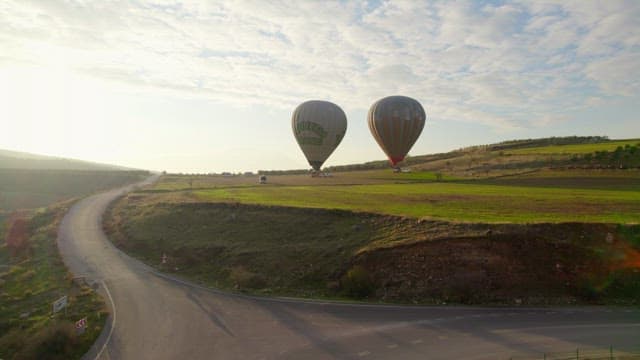 Hot Air Balloons Preparing for Flight over the Grassland
