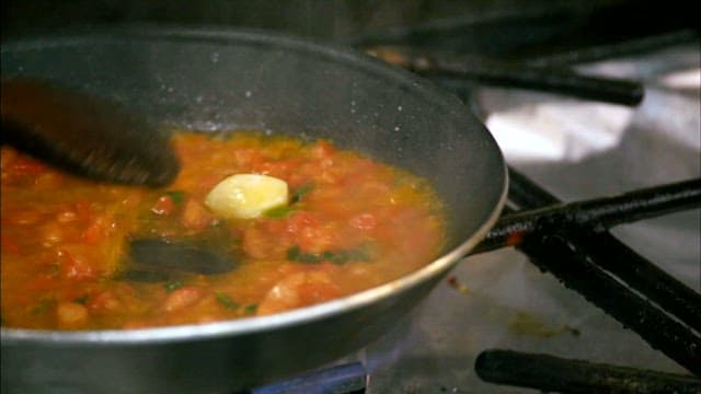 Cooking a vibrant tomato sauce on the stove in a kitchen