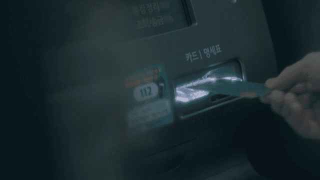 Person Inserting Card into Bank ATM