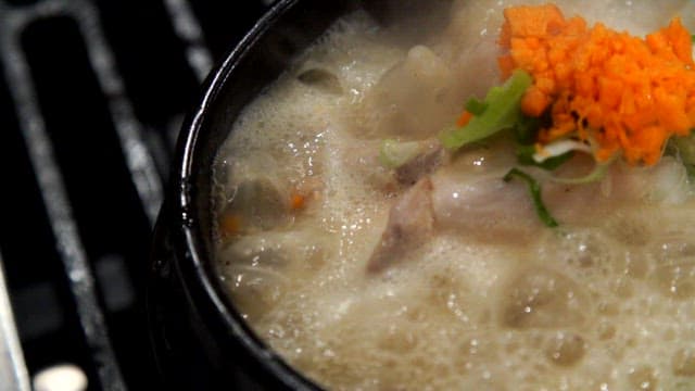 Boiling ginseng chicken soup with green onions and chopped carrots