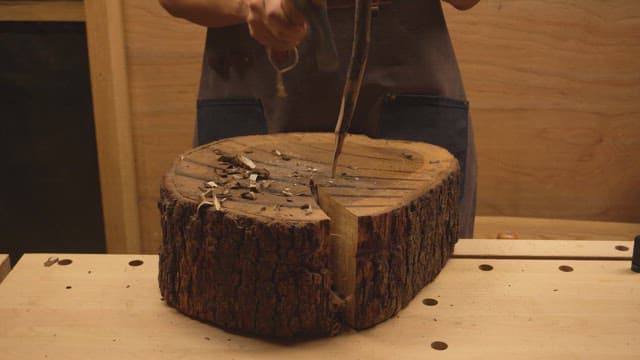 Person carving wood indoors