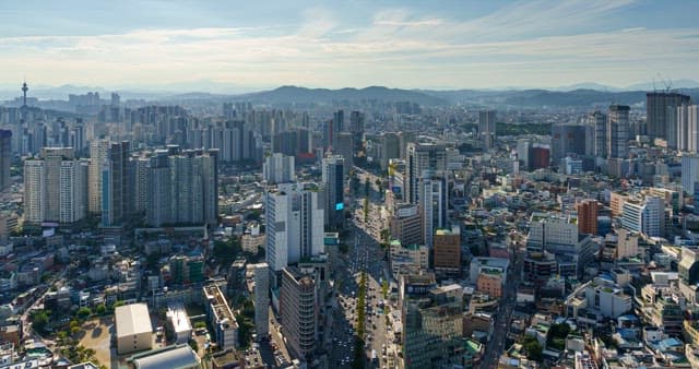 Busy scenery from day to sunset in downtown in Daegu with densely packed buildings