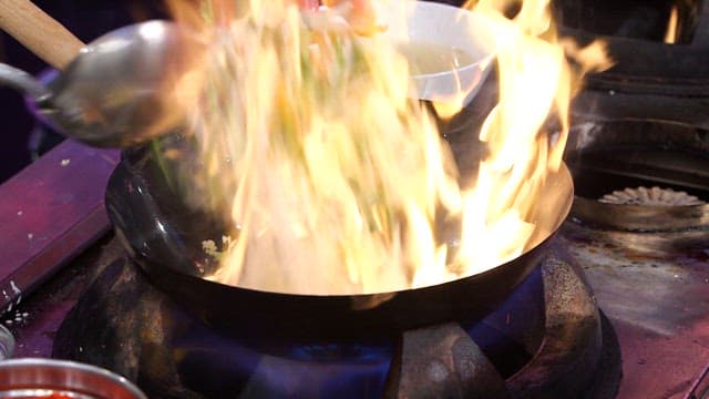 Stir-frying vegetables in a hot wok