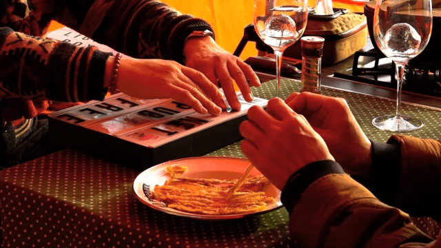 People eating snacks on cozy tables and touching light decorations