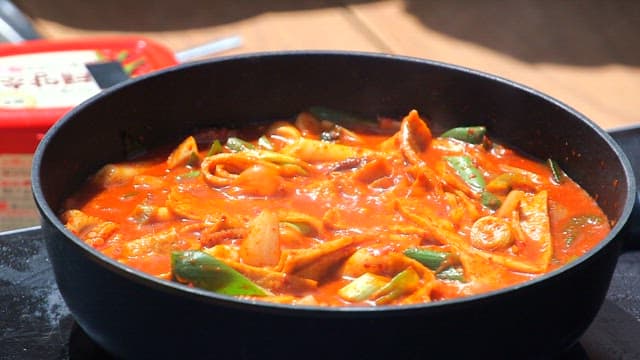 Spicy tteokbokki being cooked in a frying pan