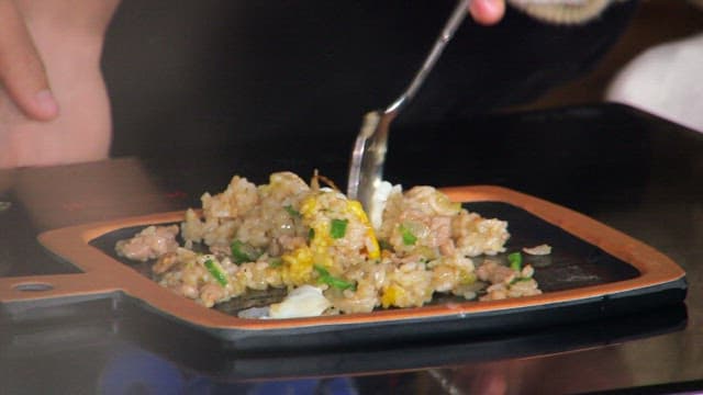 Spoonful of fried rice topped with a fried egg