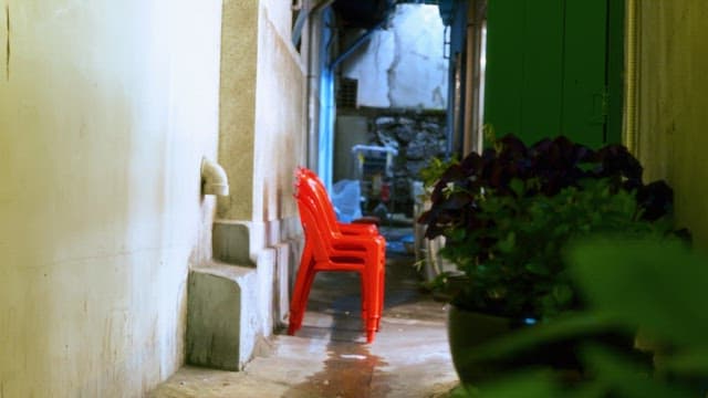 Narrow alley with stacked red chairs