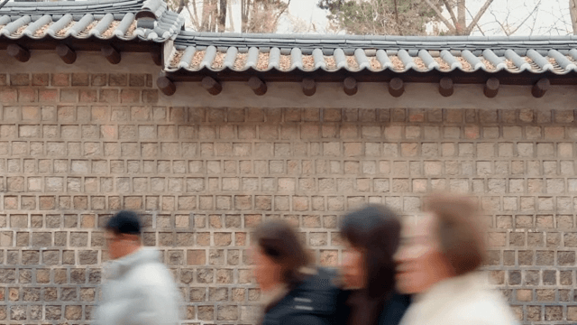 Traditional Korean wall with people passing by