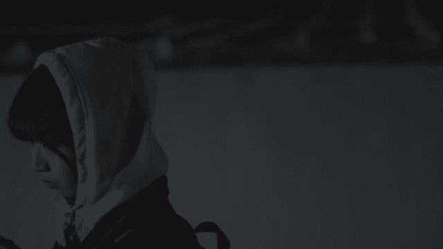 Girl walking alone with cell phone on a dimly lit street at night