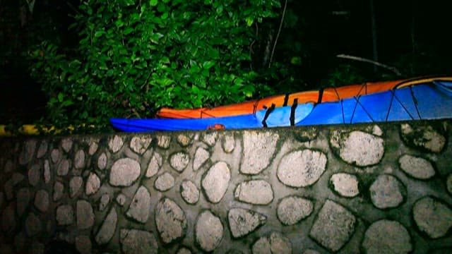 Kayak Parked by Stone Wall at Night