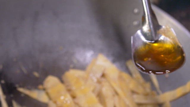 Stir-frying bamboo shoots in a wok