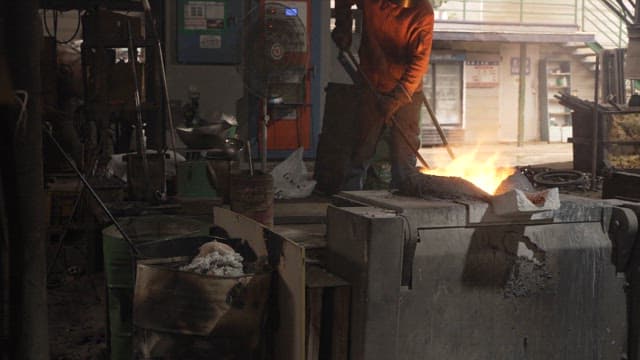 Worker handling molten metal in a foundry