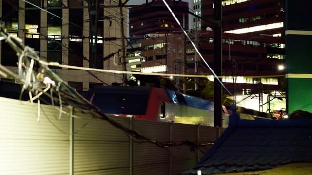 Train passing through the city buildings at night