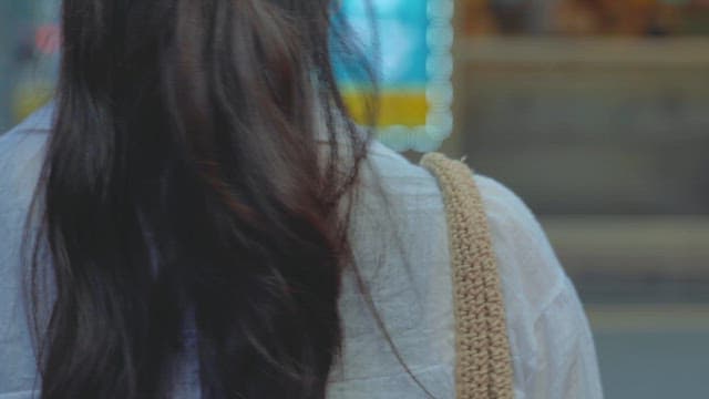 Woman in a white shirt wearing a mask walking on the street