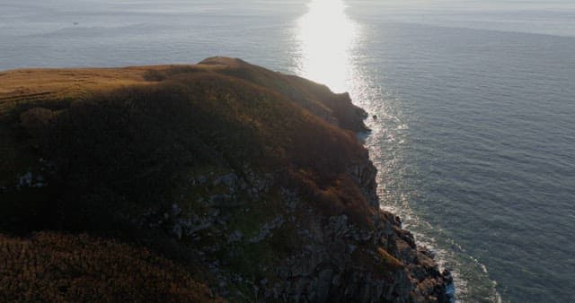 Serene Coastal Landsacape with Sun Reflecting on Water
