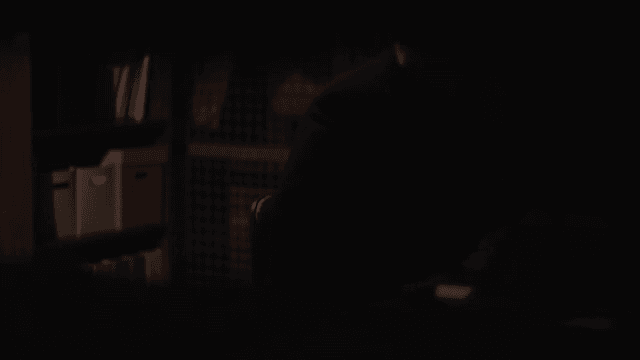 Silhouetted Man Contemplating in a Dark Office