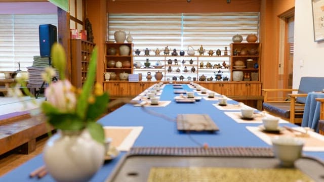 A beautifully set long table with tea settings in a traditionally decorated room