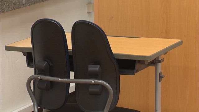 Classroom setting with empty chairs and desk