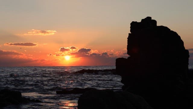 Sunset over the Ocean with Silhouetted Rock Formations