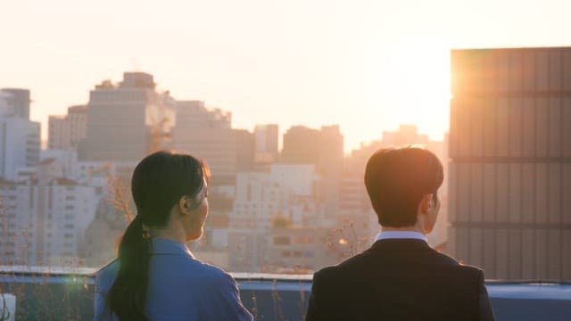 Two people conversing on a rooftop