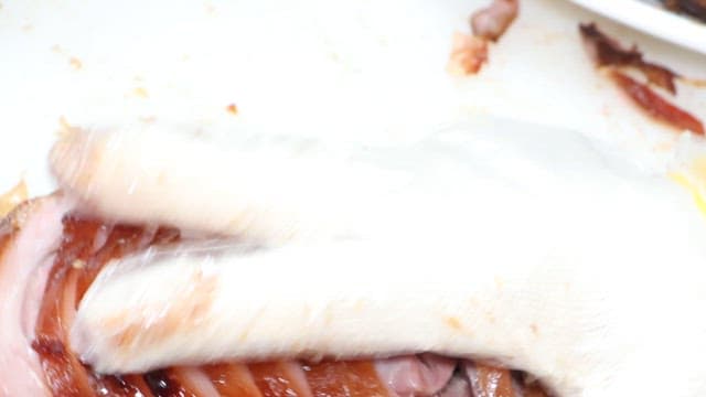 Appetizing pig's feet being served on a plate in a restaurant kitchen