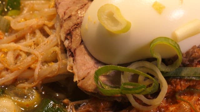 Spoonful of spicy noodles with egg and various vegetables