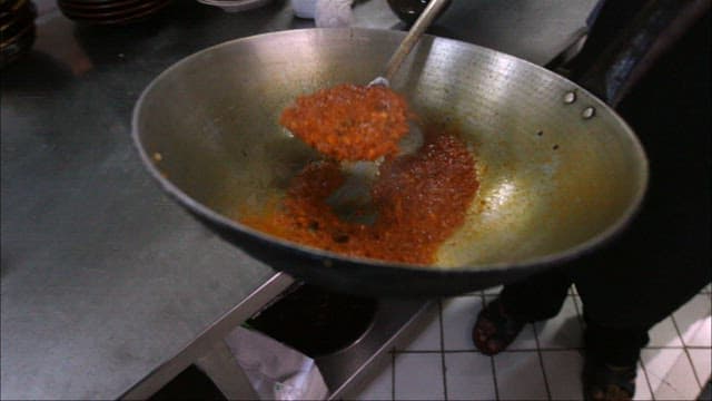 Seasoning grilled fish in a restaurant kitchen