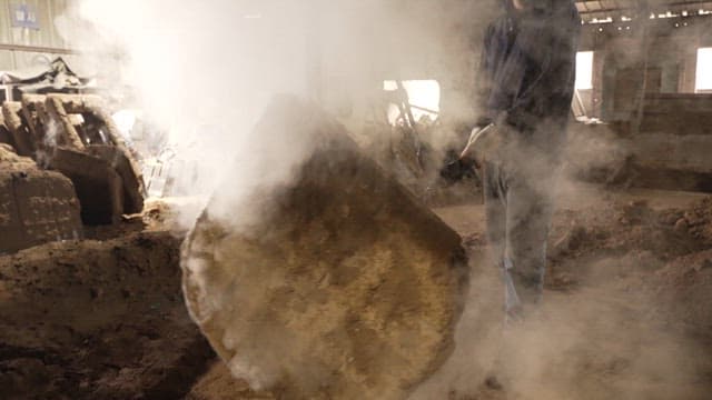 Worker handling a large metal mold