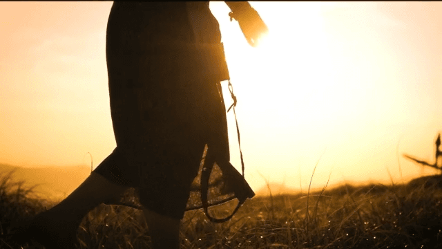 Silhouette of a person with camera at sunset