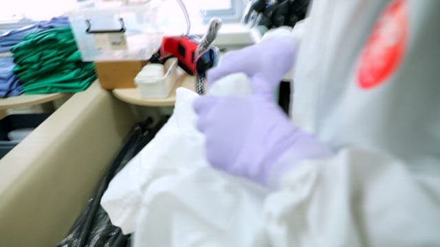 Person in protective gear handling medical equipment