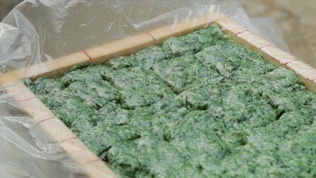 Green beewax rice cakes in a wooden tray