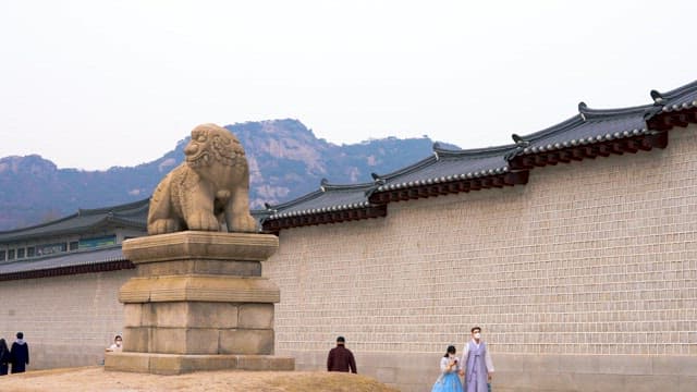 People walking near a traditional Korean haetae statue