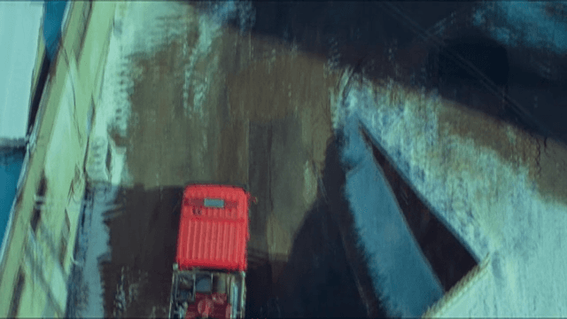 Fire Truck Running Towards a Building Charred by Fire