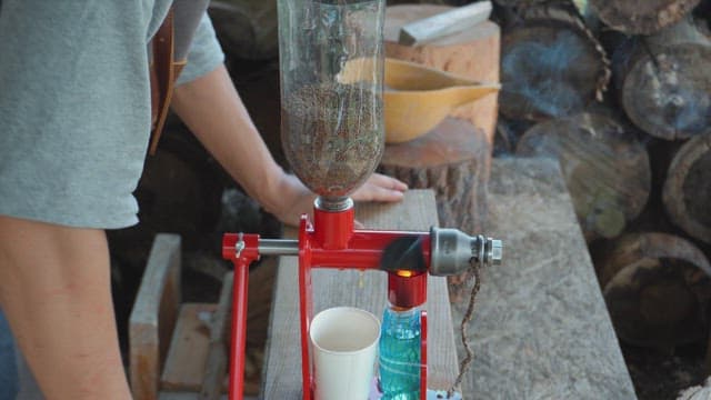 Hand pressing oil from seeds using a machine