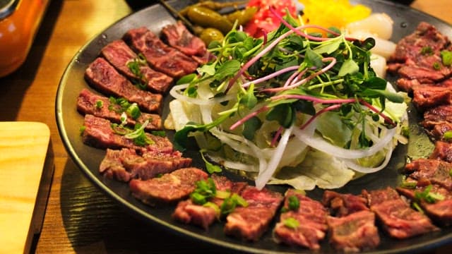 Freshly prepared vegetables and beef tataki on a plate