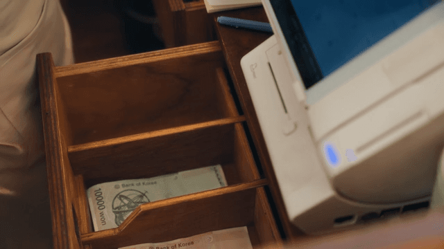 Hand reaching for cash in a drawer