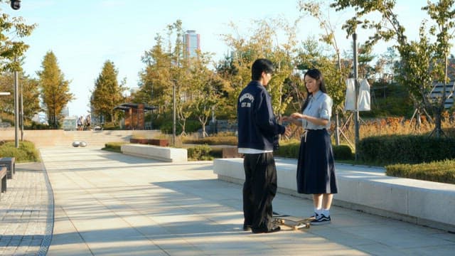 Couple learning to skateboard in a park