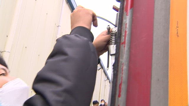 Man Marking on Lock of Cargo Trailer