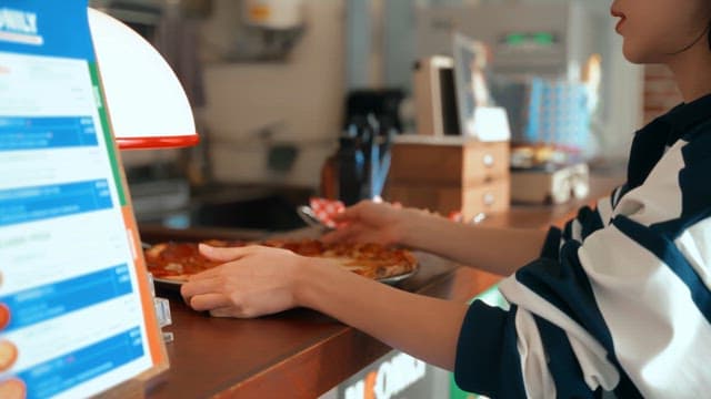 Woman serving freshly baked pizza