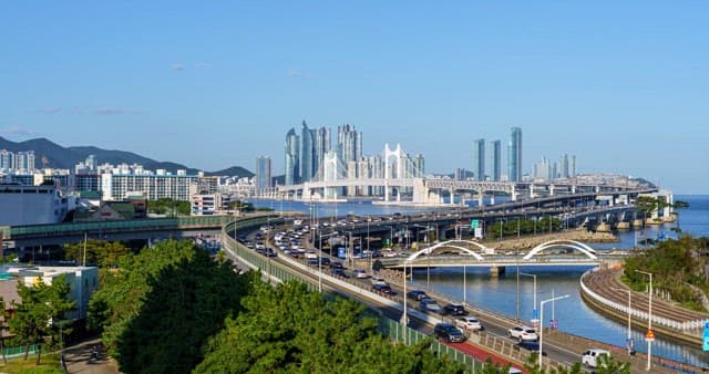 From day to night view of a bustling port city with tall skyscrapers and bridge