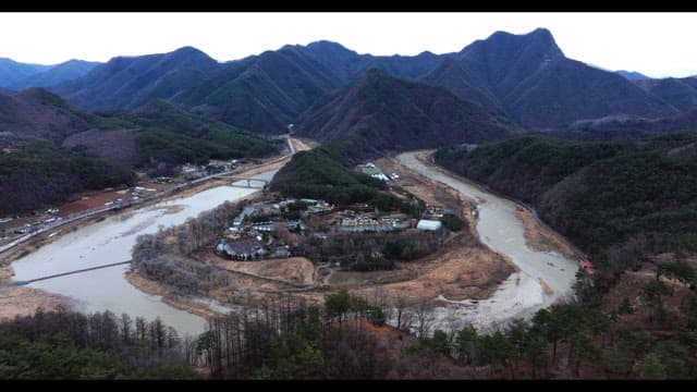 Small town surrounded by mountains and rivers on a cloudy day
