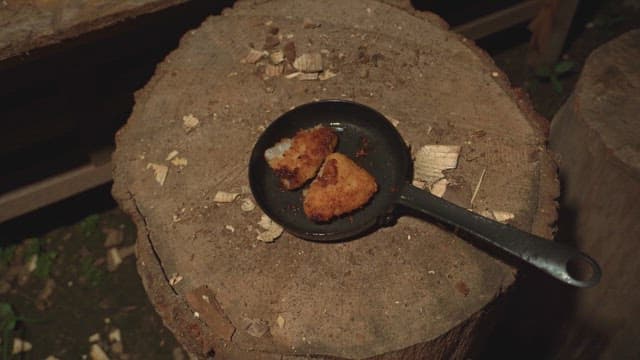 Fried food on a pan on a wooden stump
