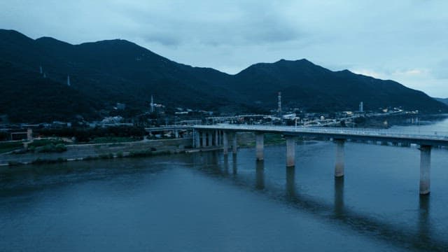 A bridge over a river with mountains
